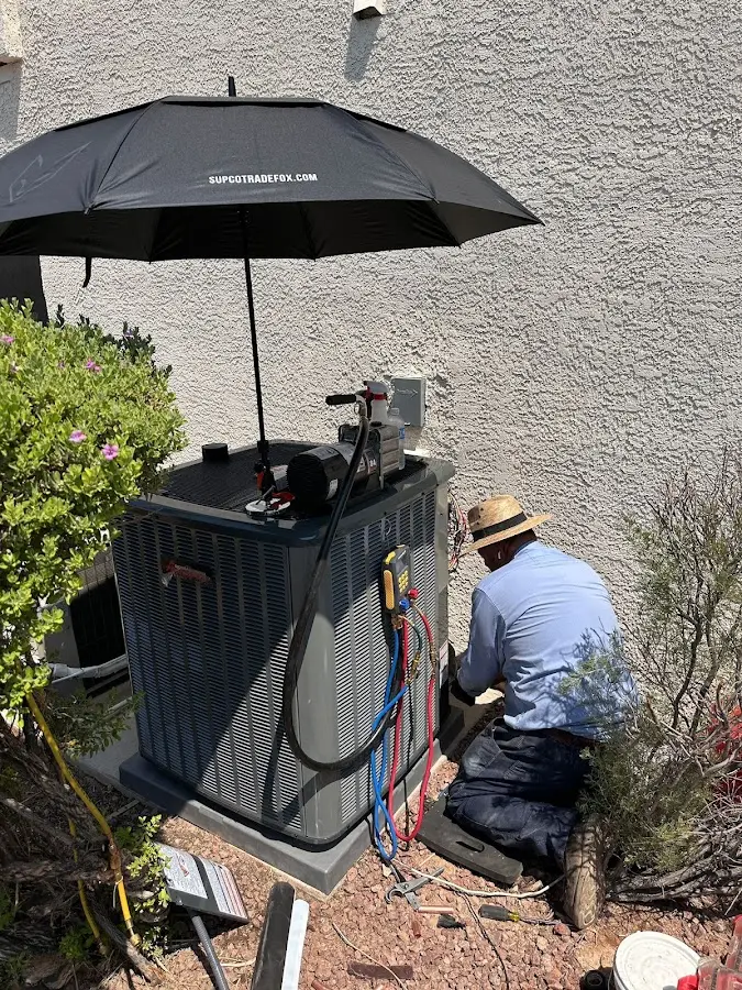HVAC technician performing outdoor AC maintenance in East Camden